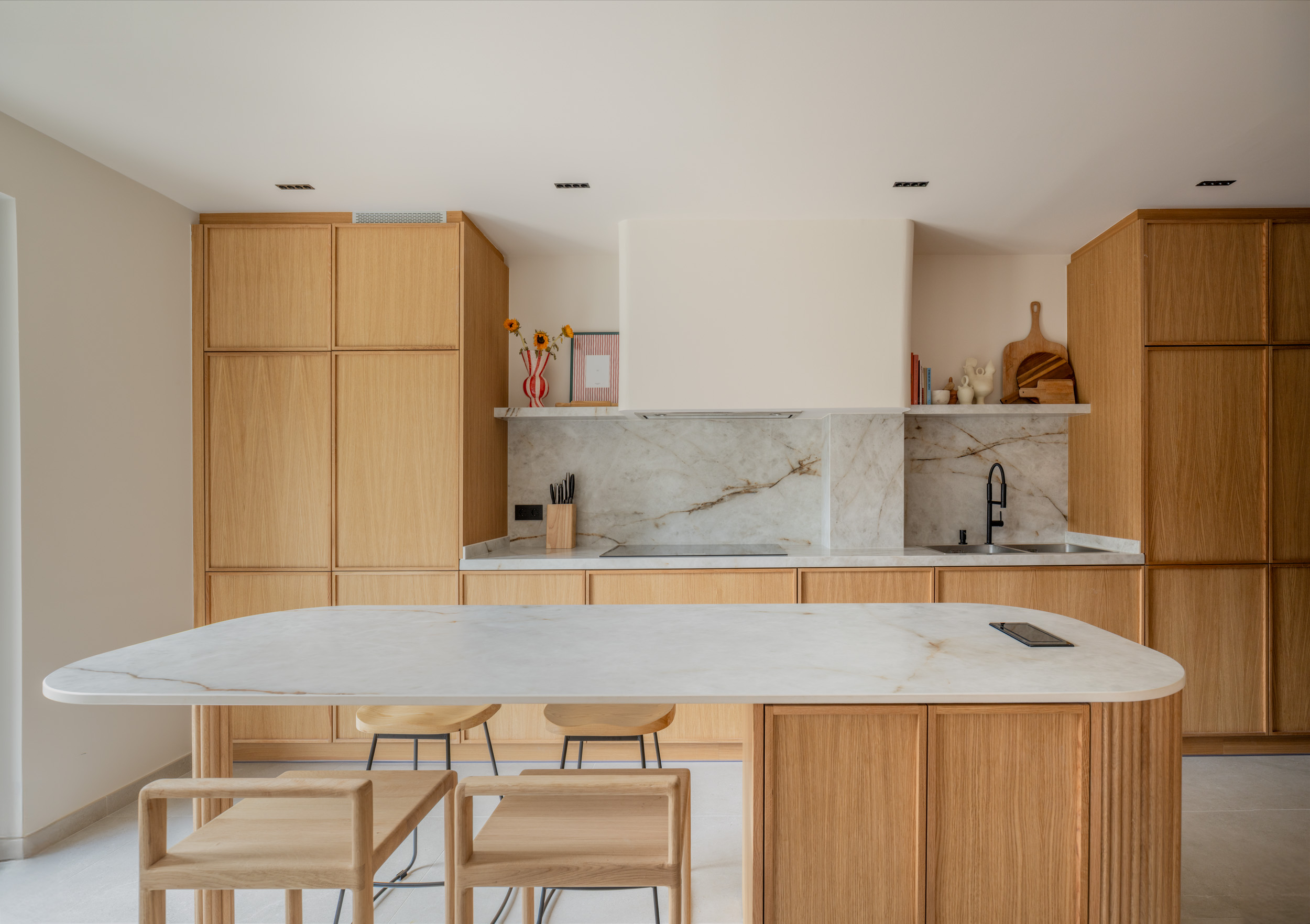 Cocina de madera, mármol blanco y grifería negra