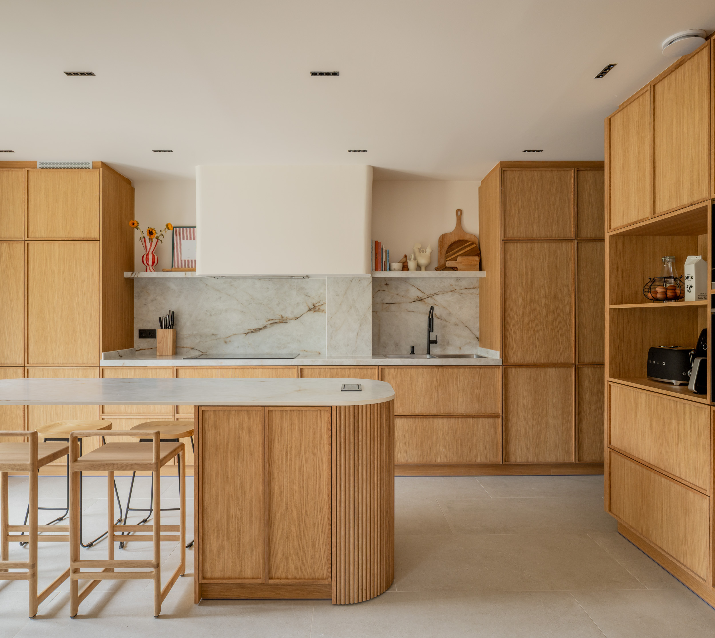 Cocina de madera, mármol blanco y grifería negra