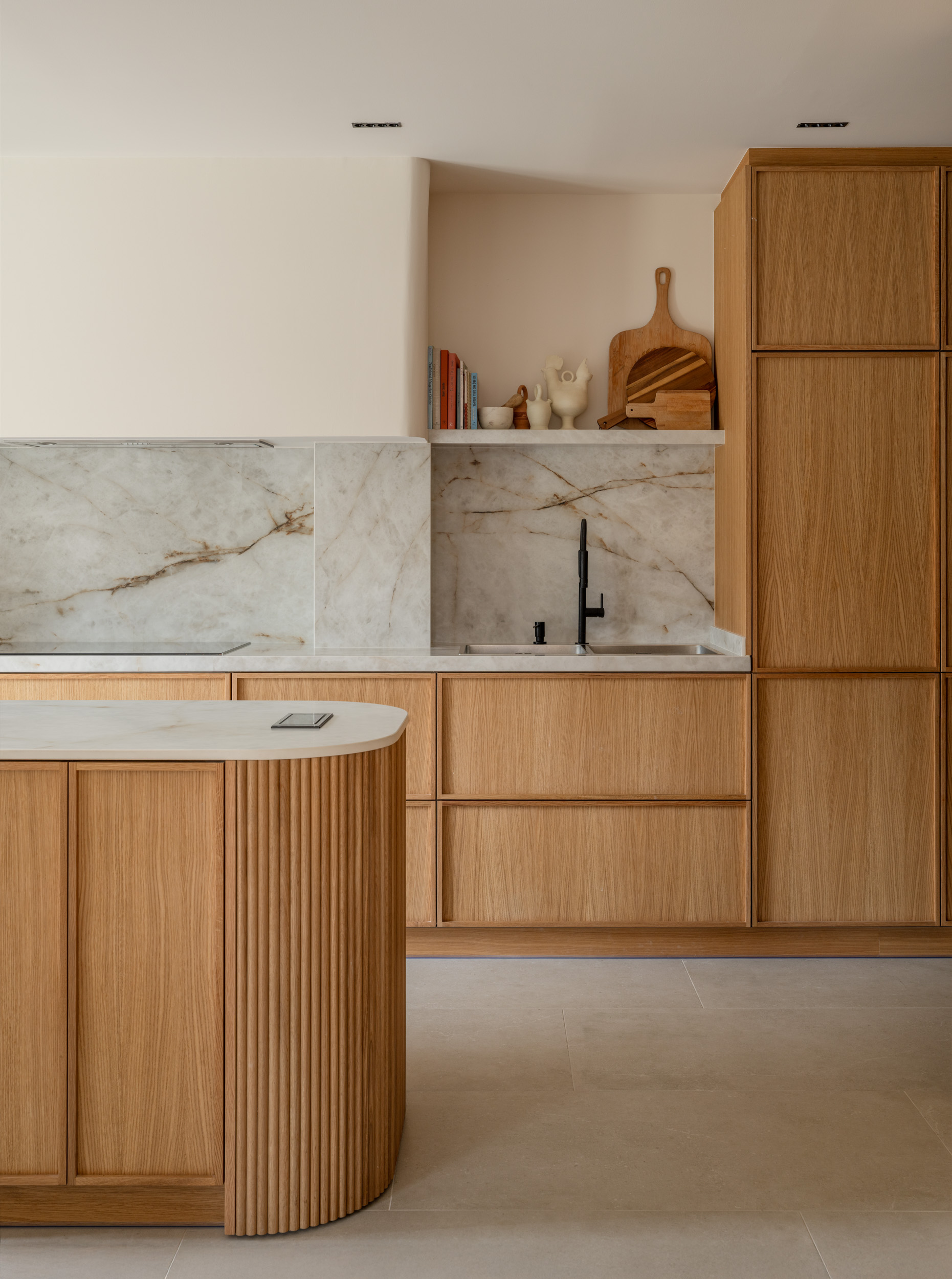 Cocina de madera, mármol blanco y grifería negra