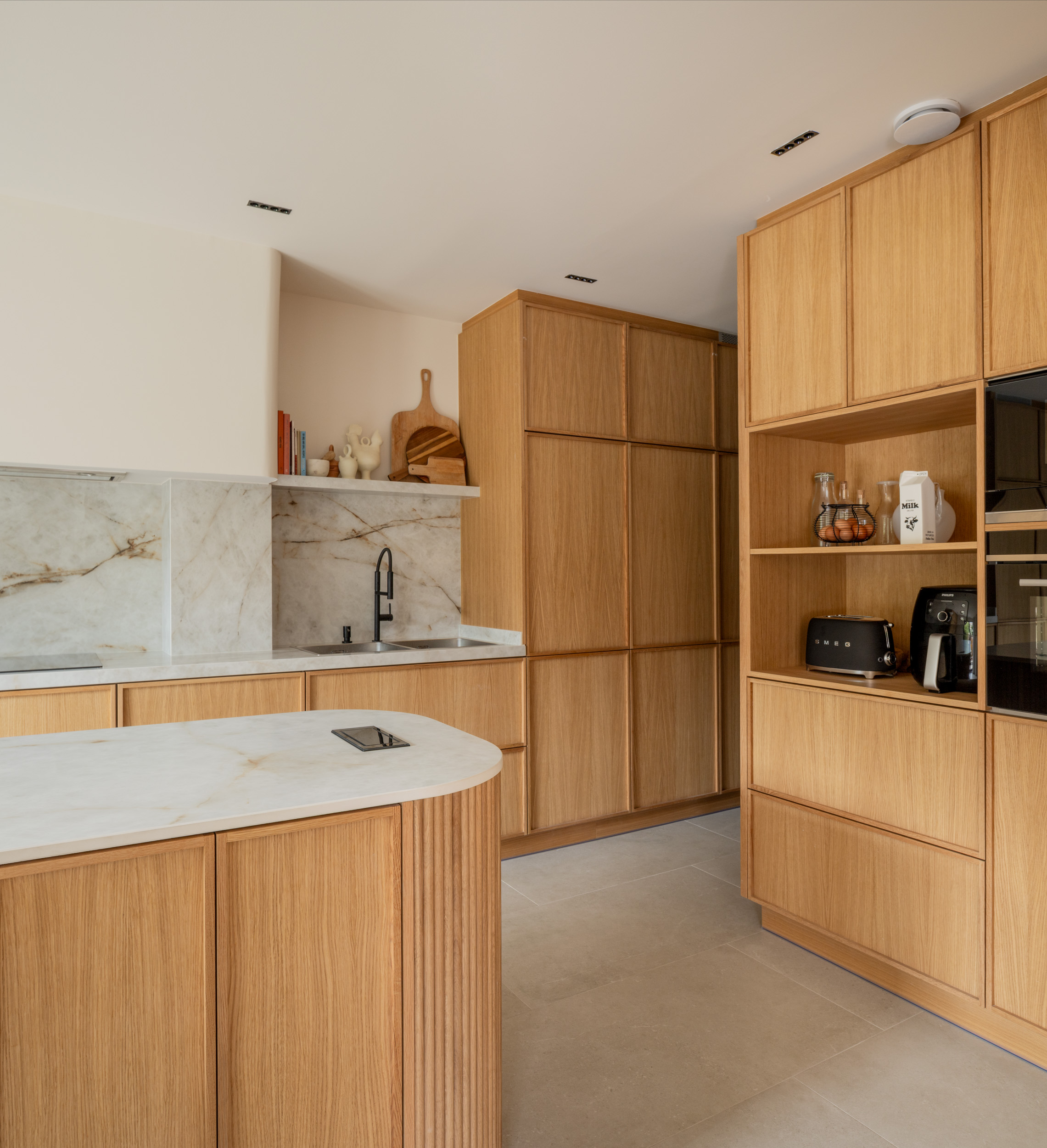 Cocina de madera, mármol blanco y grifería negra