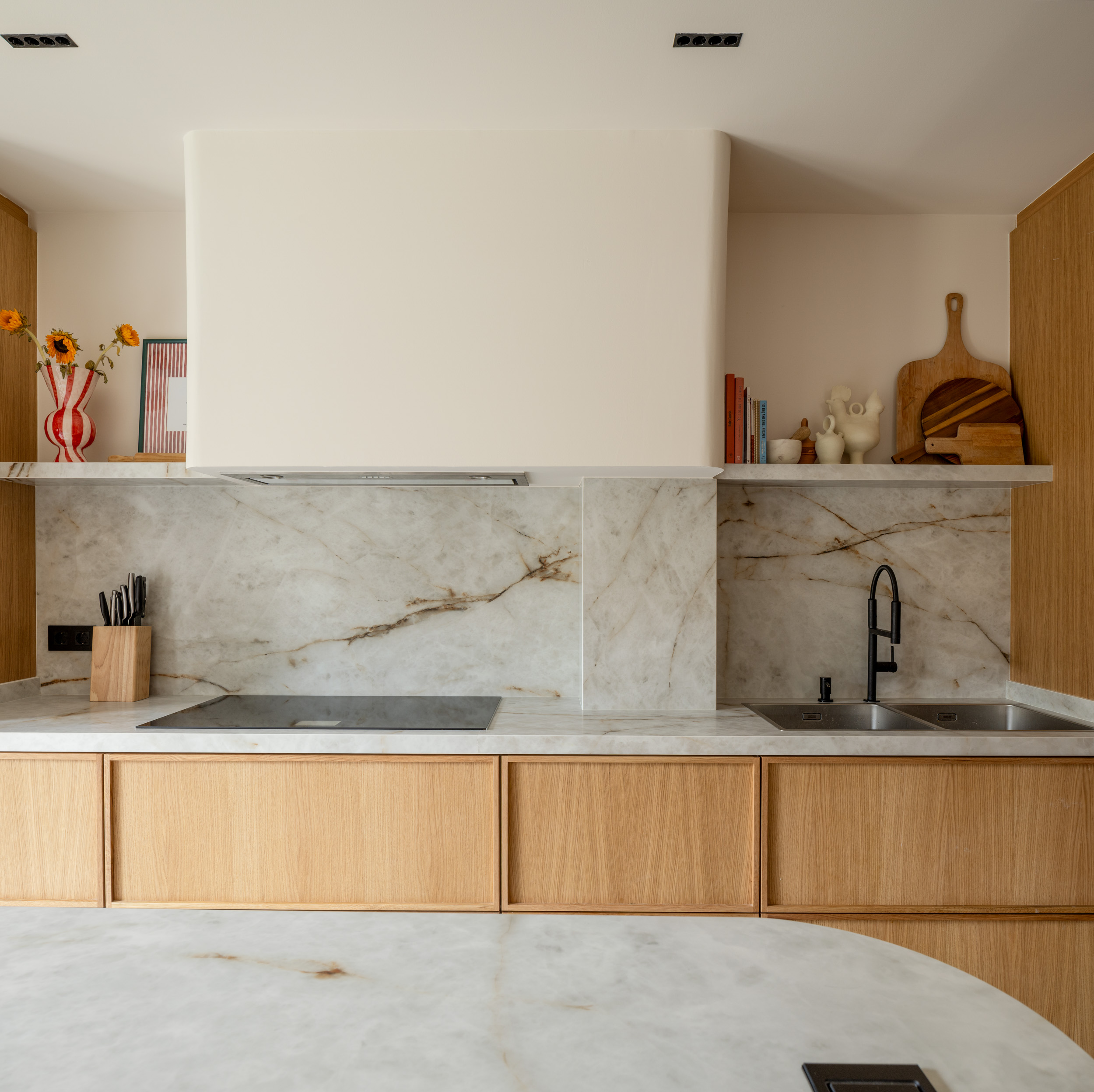 Cocina de madera, mármol blanco y grifería negra